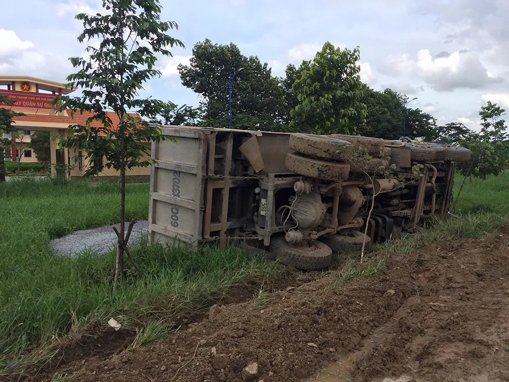 Chiếc xe tải lật nhào xuống đường, toàn bộ đá dăm xây dựng tràn ra ngoài. 